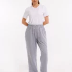 Frau trägt graue orthopädische Behandlungshose mit elastischem Bund und seitlicher Druckknopfleiste – Frontalansicht