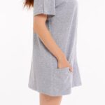 Seitliche Ansicht der Cure Adaptive Pflegekleidung für Damen – Fokus auf Taschen und Druckknopfdetails am Ärmel.