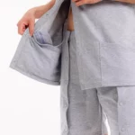 Pflegekleidung mit offener Seitenpartie und Druckknöpfen – praktischer Zugang für Patienten.