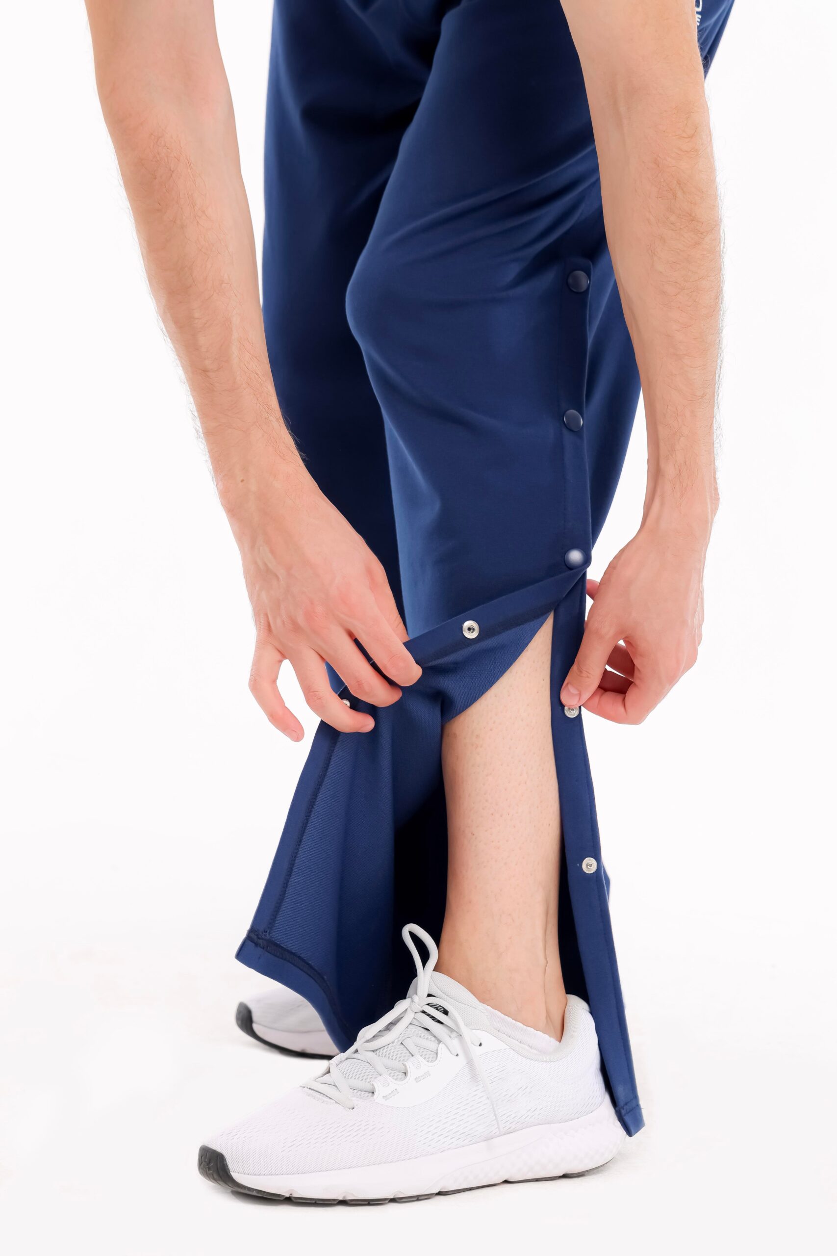 Mann öffnet seitliche Druckknöpfe der orthopädischen Pflegehose – einfache Handhabung für Therapie und Pflege
